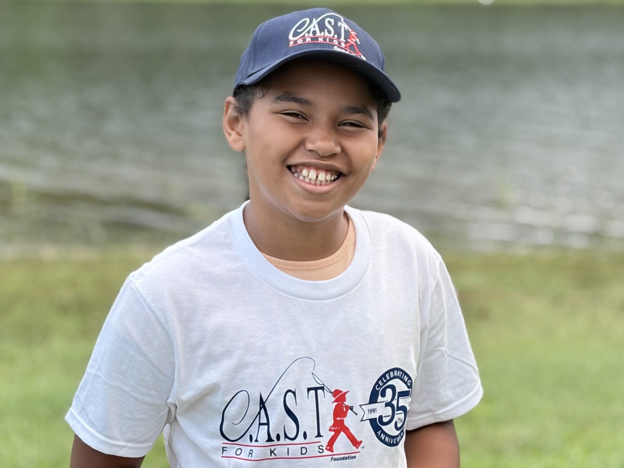 participant holding fish at central lake pond