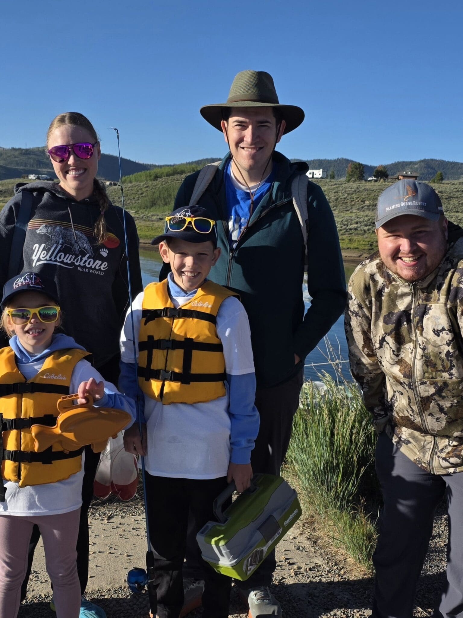 child with life jacket holding fish at strawberry reservoir
