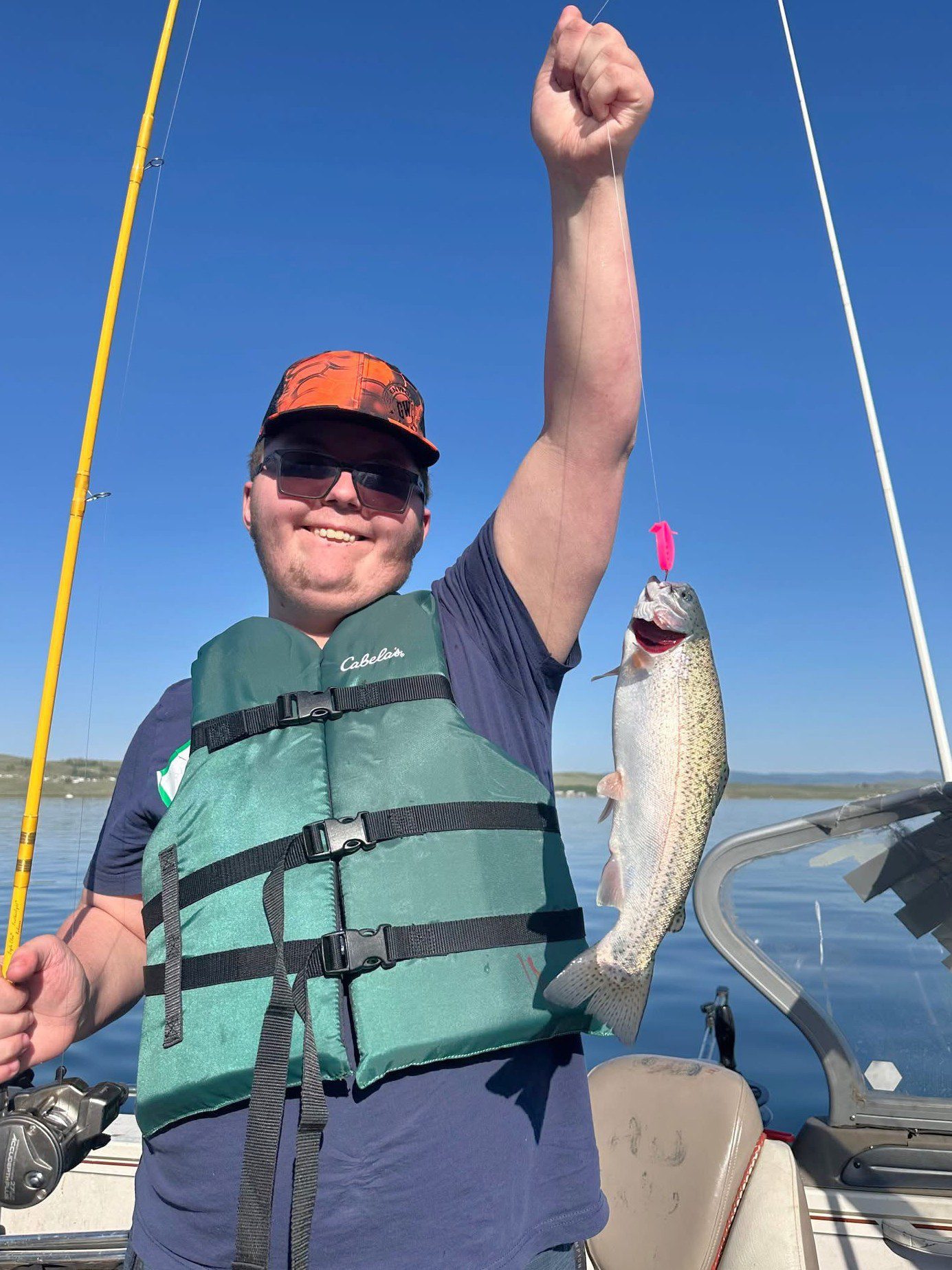 child with life jacket holding fish at strawberry reservoir