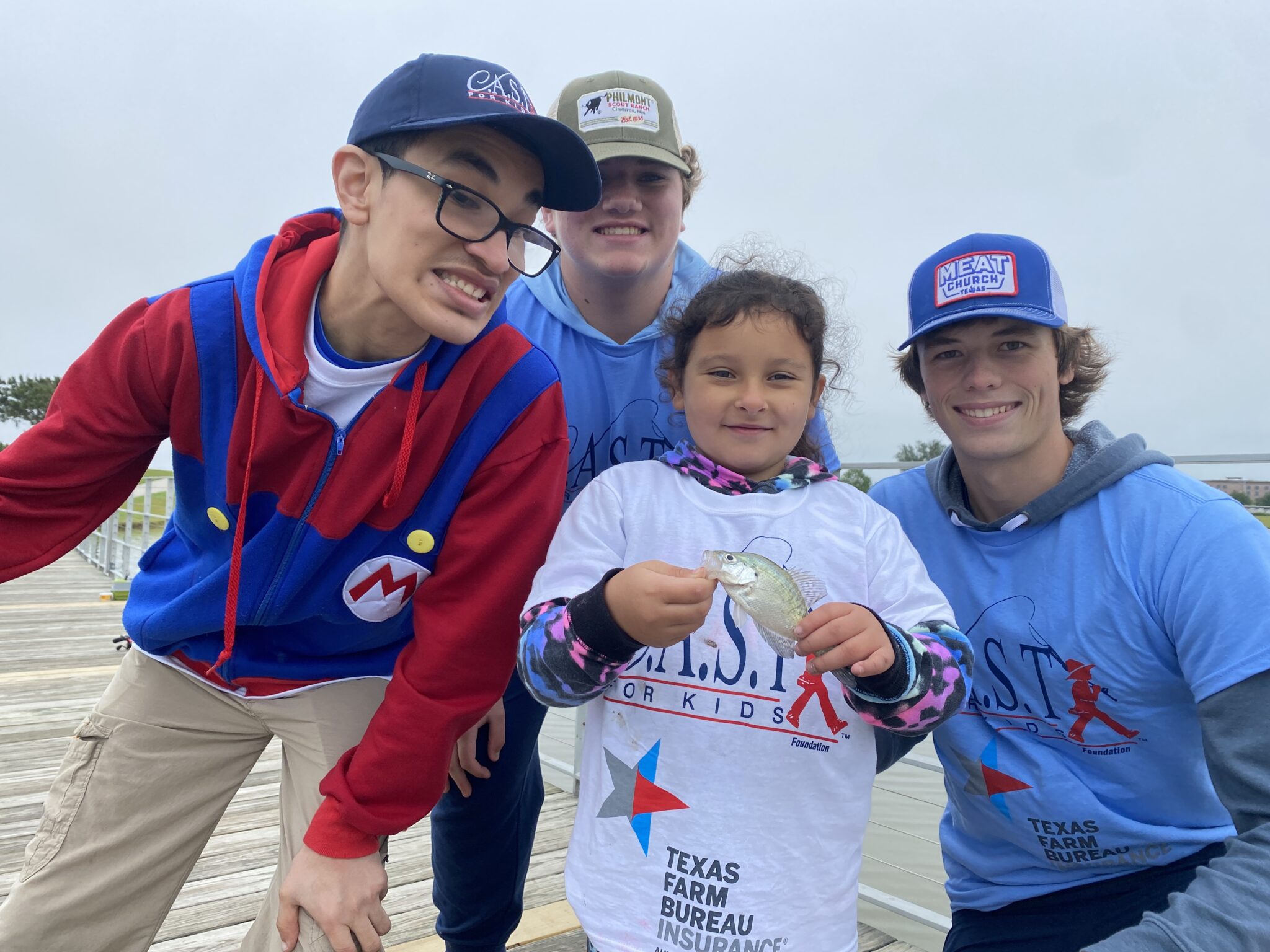 volunteers with a caught fish with young people