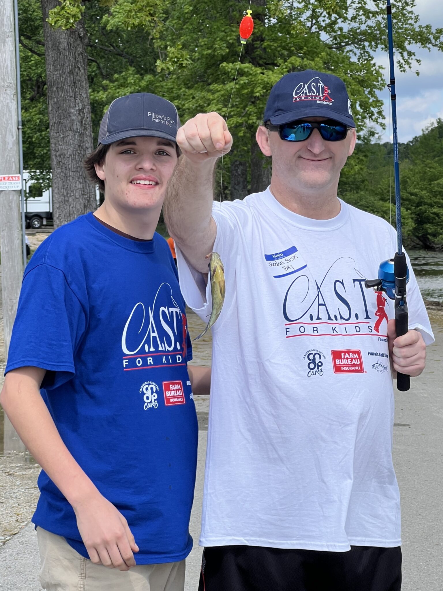 boy holding a fish with a life jacket on