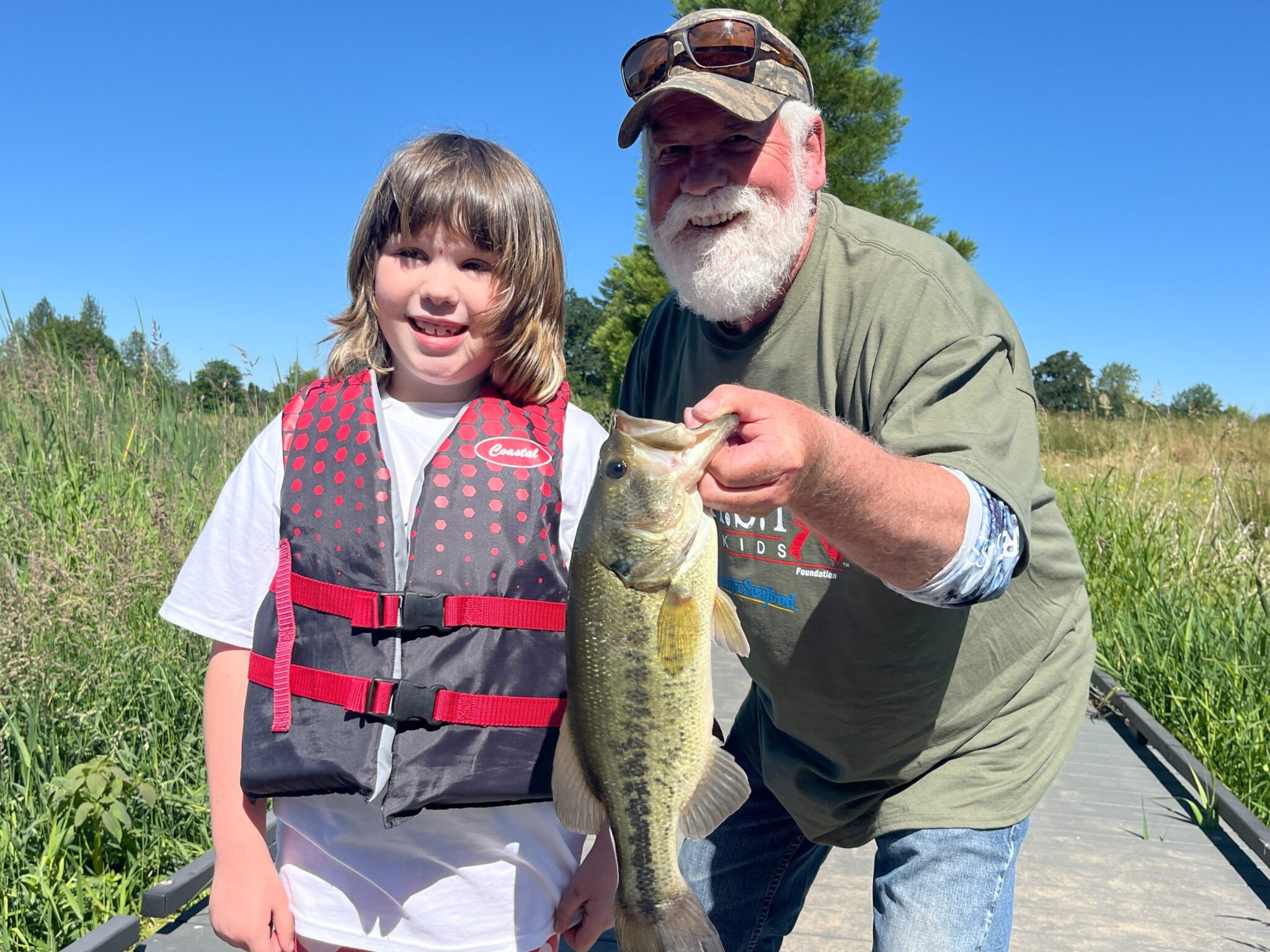 young girl and older man showing off fish at lake charles