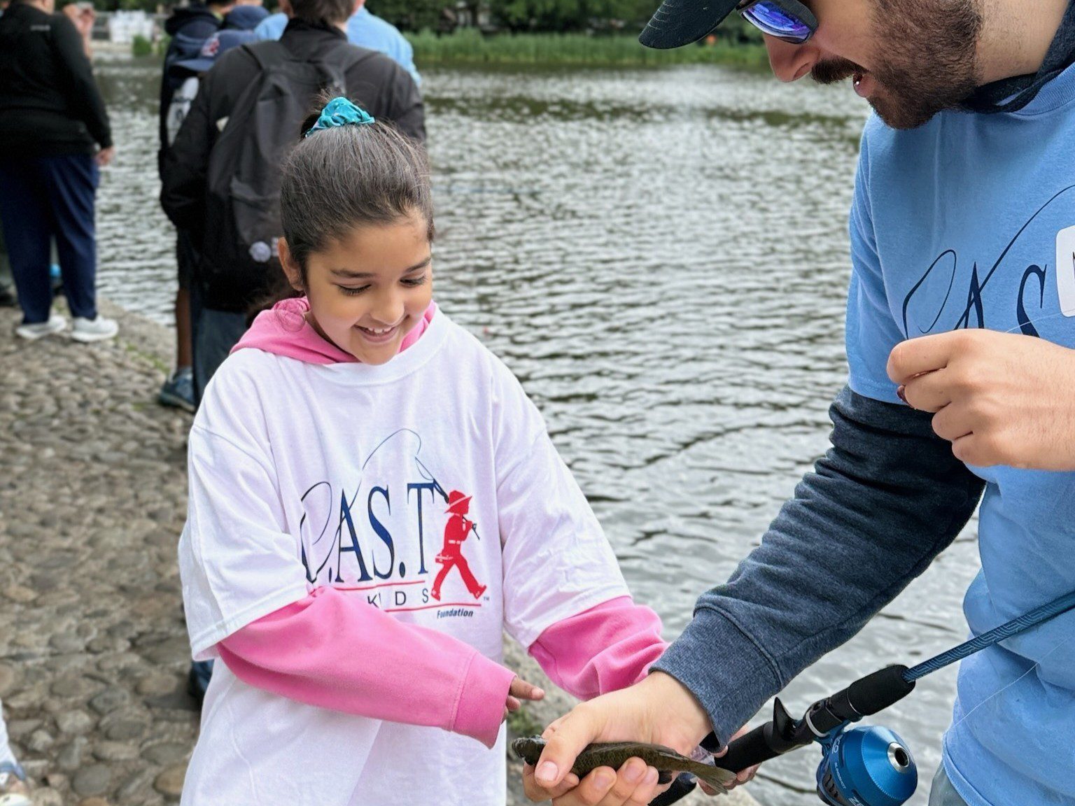 young girl showing fish at harlem meer