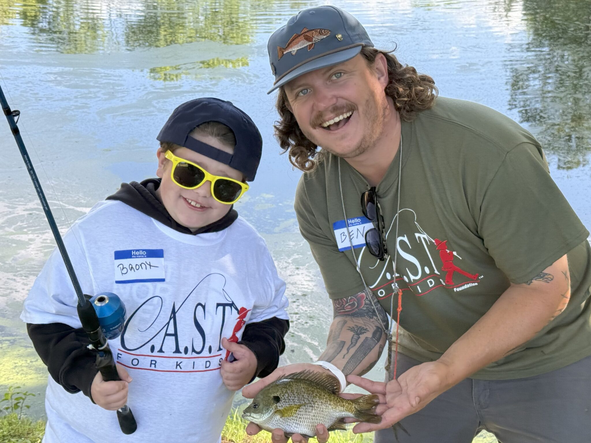 child and adult holding fish at spotted dog pond