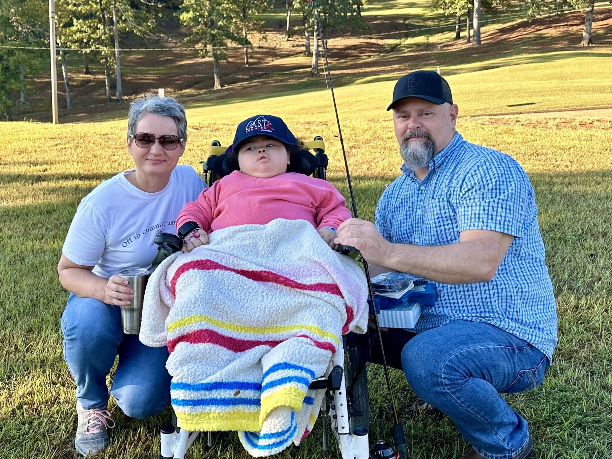 two participants holding fish at central lake pond