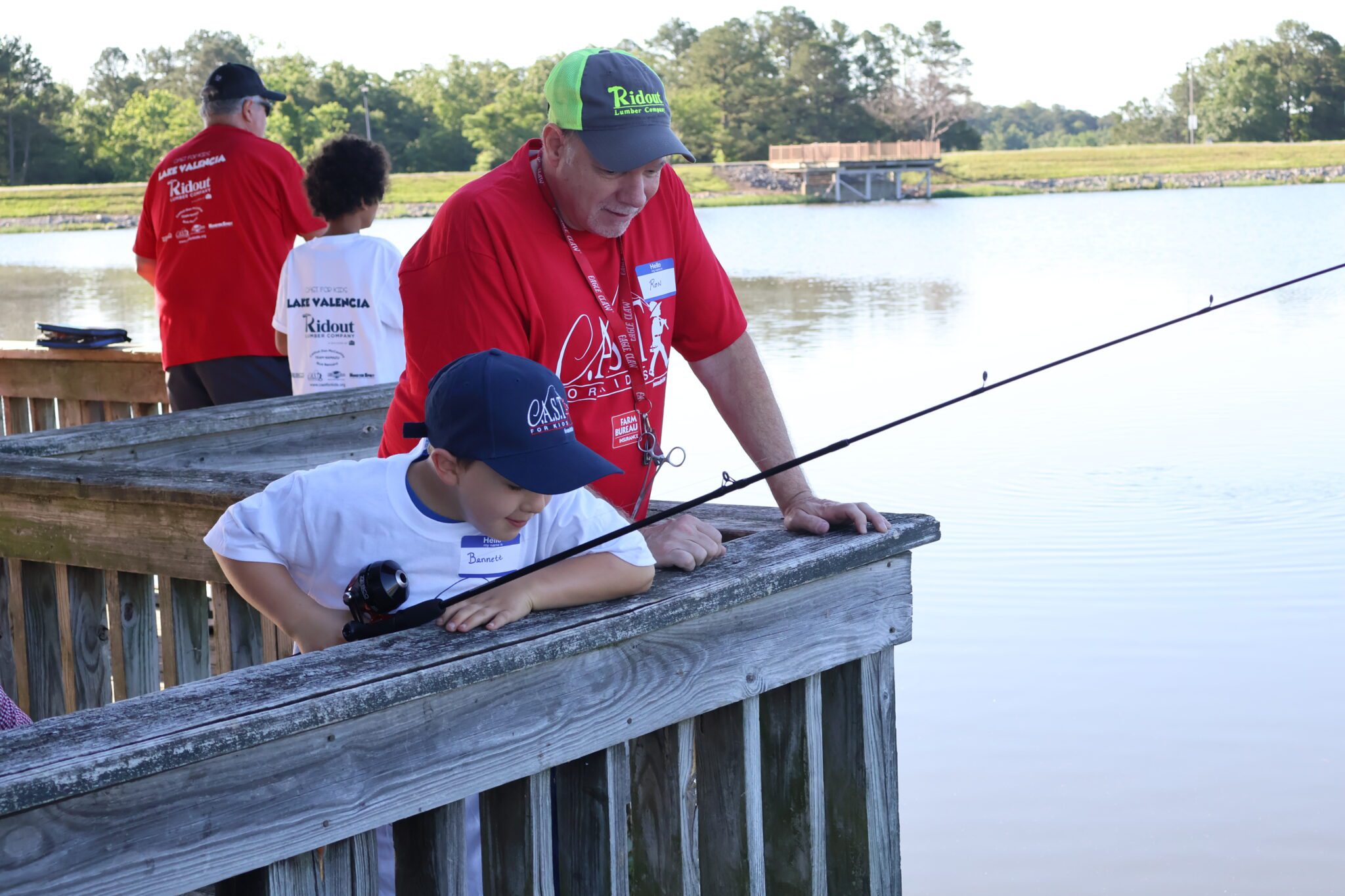 volunteer on a deck fishing with a child