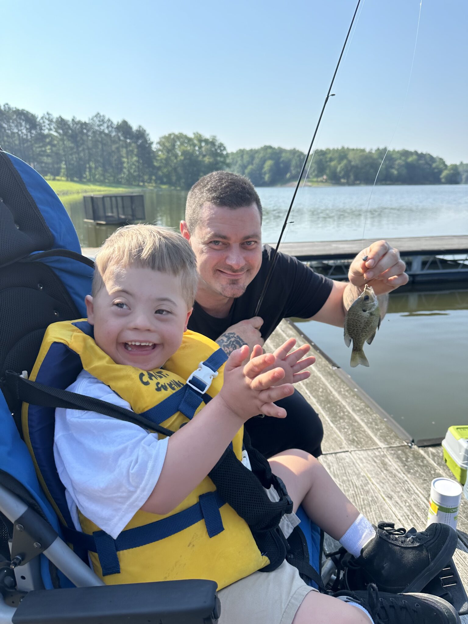 a special needs child clapping after he caught a fish