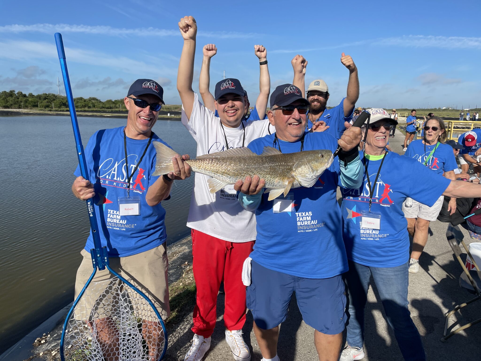 volunteers with a caught fish with young people