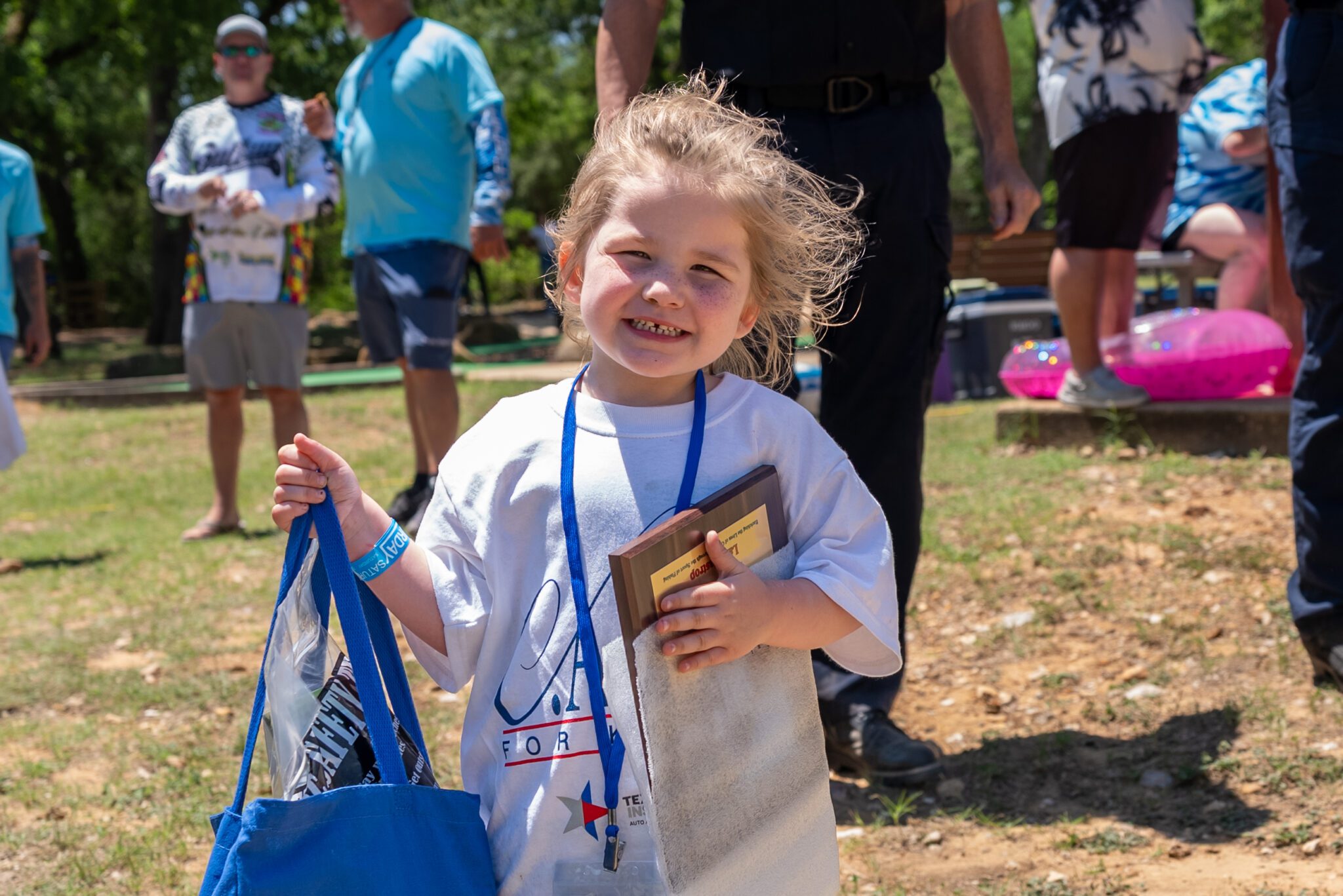 young girl holding a bag and a fishing plaque